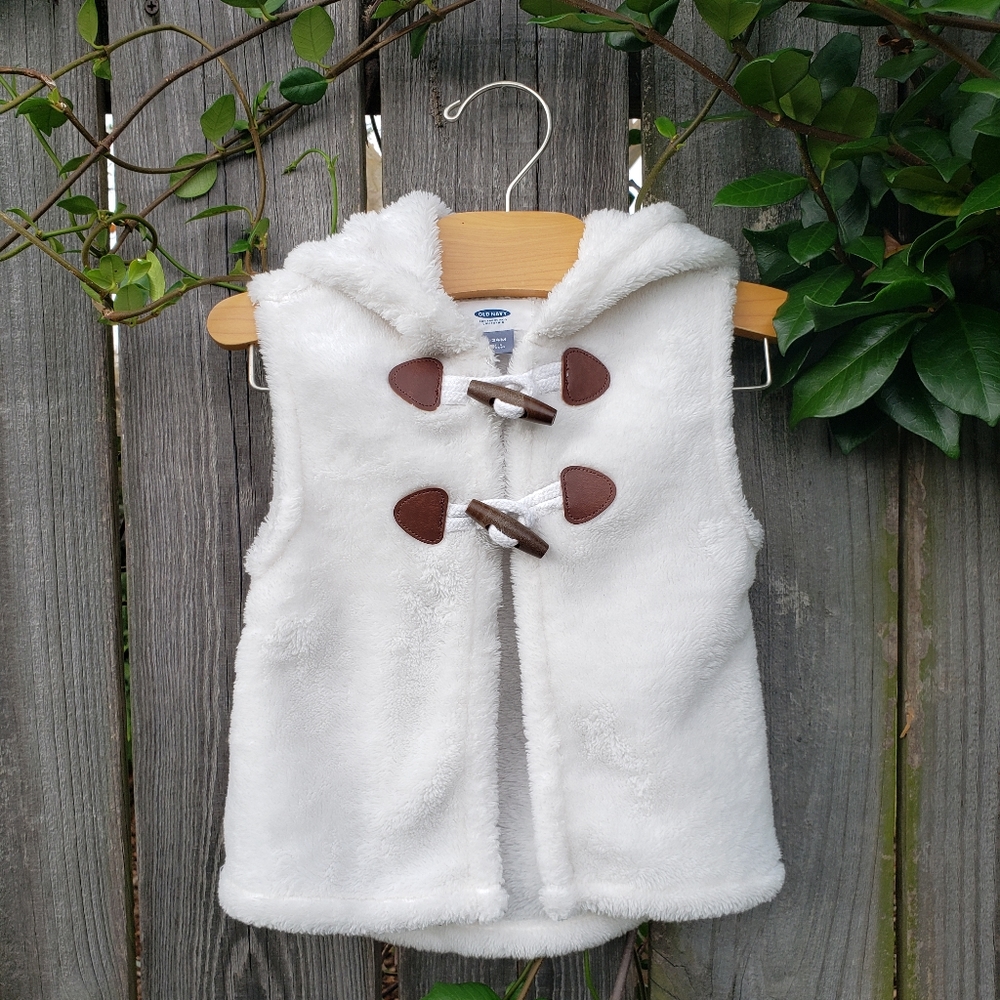 Fluffy white hoodie vest with brown toggle clasps